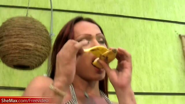 Redhead T-girl in see through dress enjoys her banana rama