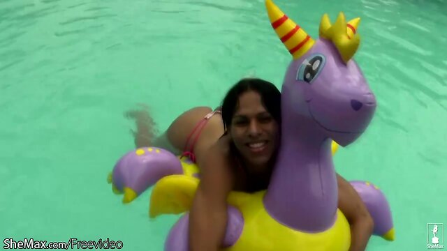 Cheerful teen shemale shows off sexy ass in thongs poolside