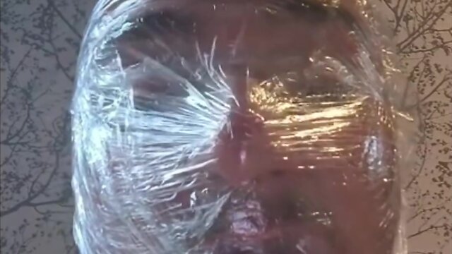 Breath play in latex catsuit with cling film