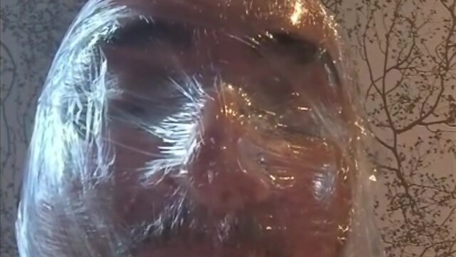 Breath play in latex catsuit with cling film