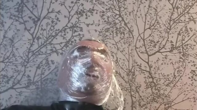Breath play in latex catsuit with cling film