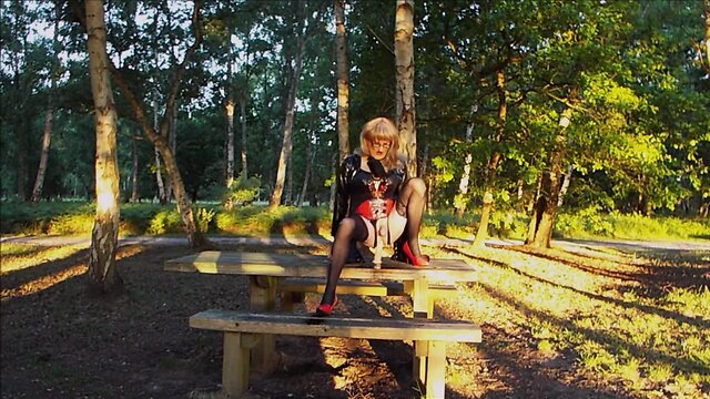 Trans person in pvc outfit enjoys machine sex on picnic table