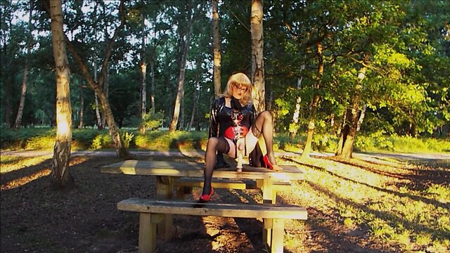 Trans person in pvc outfit enjoys machine sex on picnic table