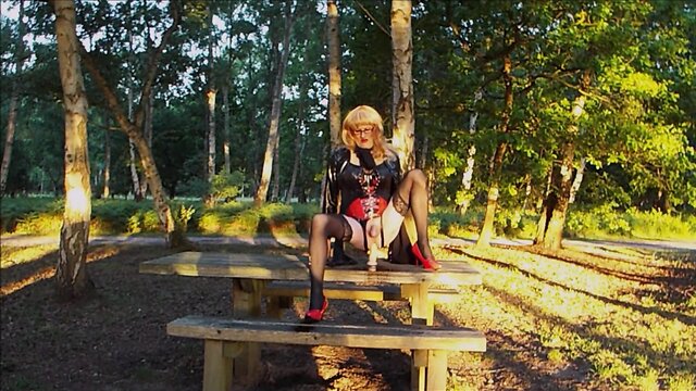 Trans person in pvc outfit enjoys machine sex on picnic table