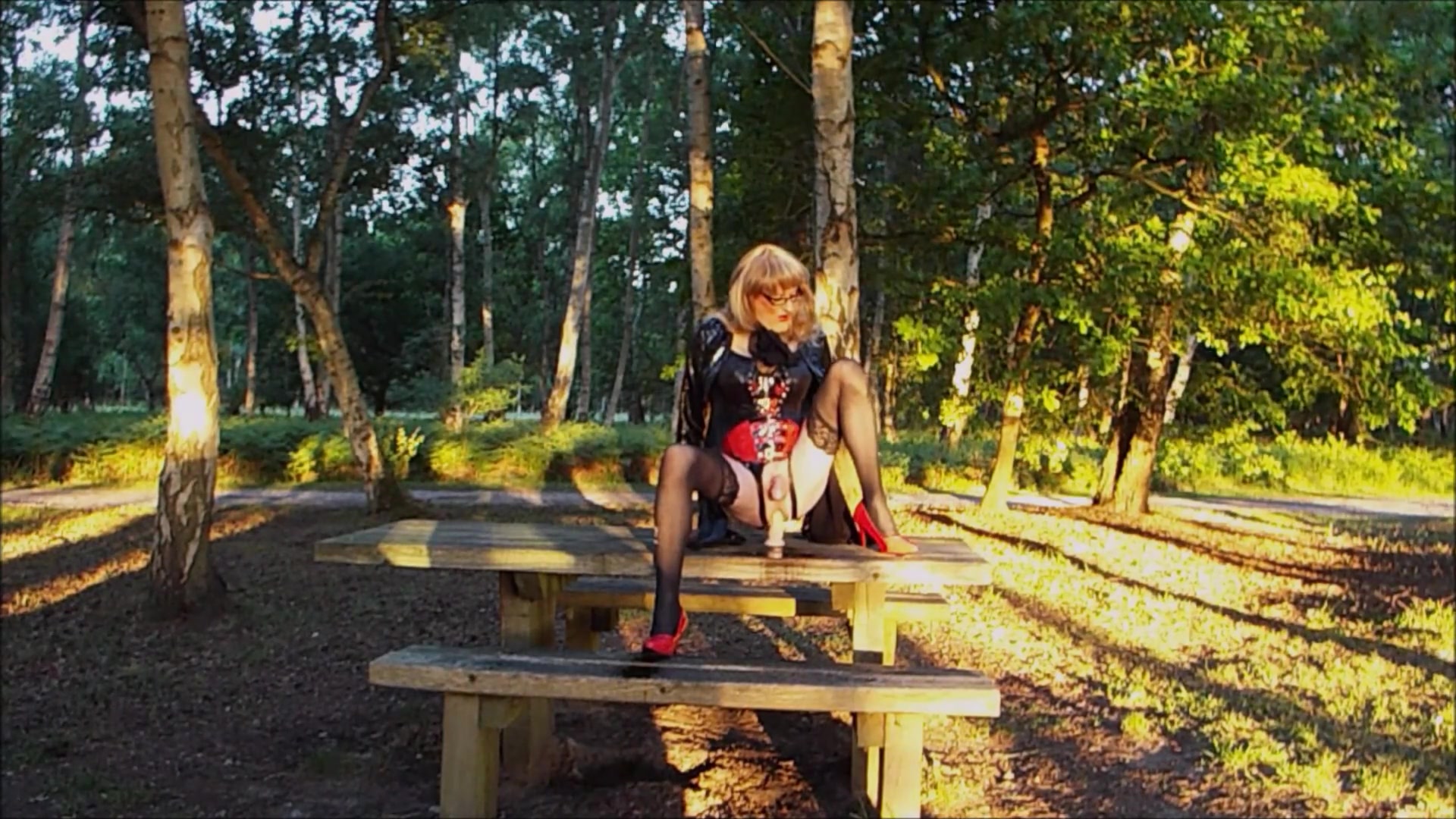 Trans person in pvc outfit enjoys machine sex on picnic table