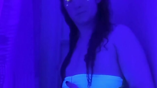 Trans person in bikini strips, showers, and plays under black light