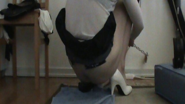 Chained tgirl sits on a dildo